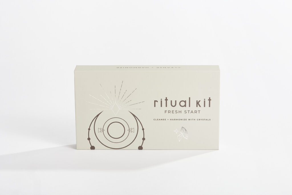 A taupe, rectangular box labeled "Ritual Kit: Fresh Start" with a dream catcher graphic on the box. The product feature for virgo new moon.
